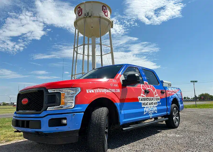 AC and Plumbing Service Truck in front of Norman, Oklahoma water tower